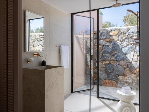 a bathroom with a stone wall at Cape Sounio, a Resort to Live in Sounio