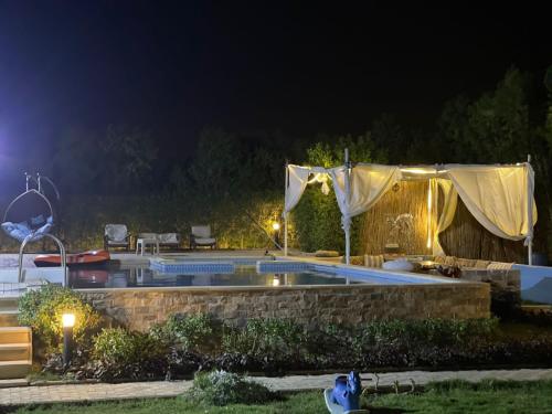 a swimming pool in a yard at night at Dija's holiday rental in Al Qaţā