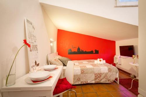 a bedroom with a bed with an orange wall at Dimora Pastini in Rome