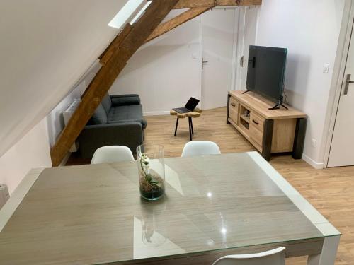 a living room with a table and a tv at Appartement Cosy, Résidence de l’Ecluse in Arques
