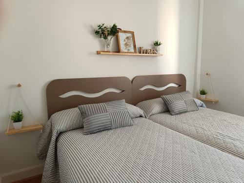 a bedroom with a bed with striped sheets and pillows at Apartamento céntrico La Morada Santanderina in Santander