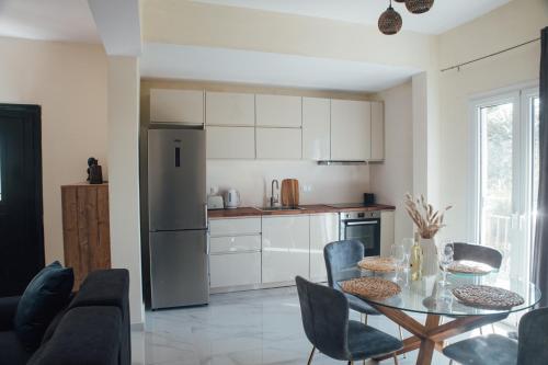 a kitchen with a table and chairs and a refrigerator at Captain's Apt in Arillas