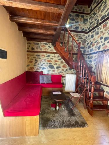 a room with a red bed and a staircase at Gioras Hotel in Palaios Agios Athanasios