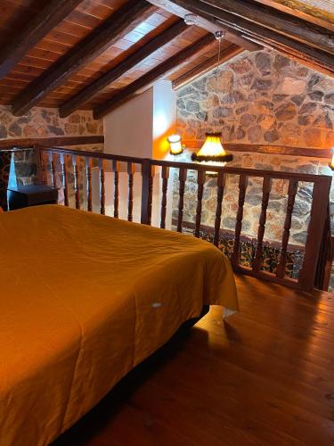 a bedroom with a bed in a room with a stone wall at Gioras Hotel in Palaios Agios Athanasios