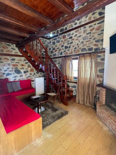 a bedroom with a red bed and a staircase at Gioras Hotel in Palaios Agios Athanasios