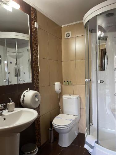 a bathroom with a toilet and a sink and a shower at Gioras Hotel in Palaios Agios Athanasios