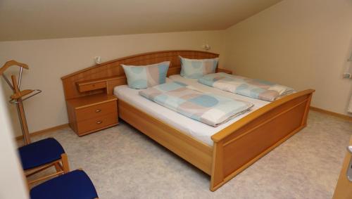 a bedroom with a large wooden bed with blue pillows at Uhlenflucht in Spelle