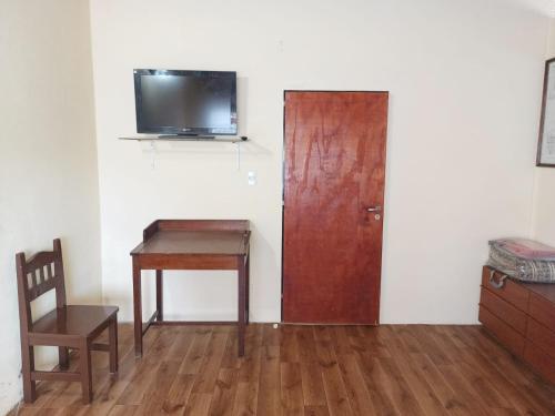 a room with a door and a desk and a tv at Alojamiento turístico NFG in San Carlos de Bariloche