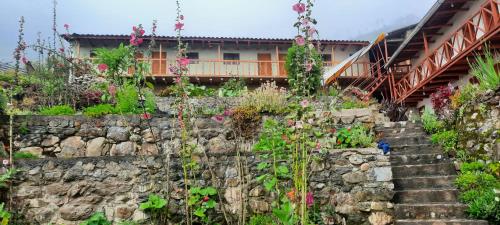 una pared de piedra con escaleras delante de una casa en Hospedaje Wayna Pakaq, en Huanipaca