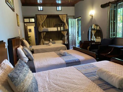 a bedroom with two beds and a mirror at RUAJ HOSTAL -Wellness-Colonial-Exclusive- in Antigua Guatemala
