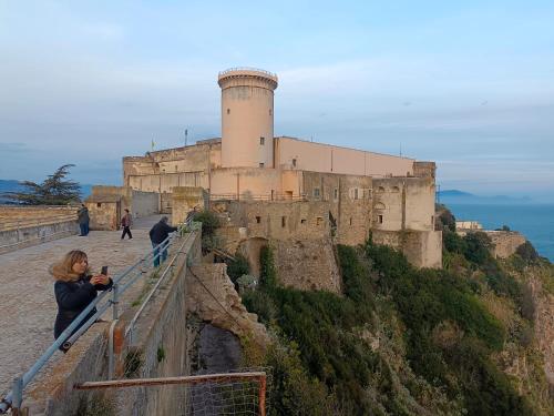 Kobieta robi zdjęcie zamku. w obiekcie Country House Gaeta w mieście Gaeta