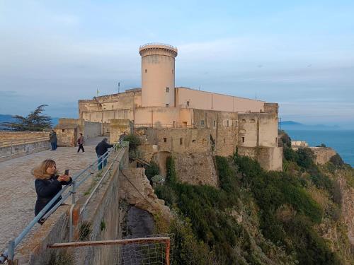 una mujer está tomando una foto de un castillo en Country House Gaeta, en Gaeta