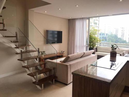 a living room with a staircase and a couch and a television at Duplex - 2 dormitórios (único c/ closet)¹⁷¹⁵ in Sao Paulo