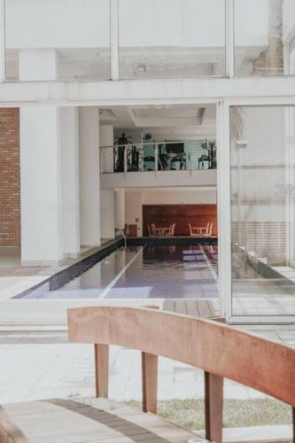 a bench in a large building with a pool at Duplex - 2 dormitórios (único c/ closet)¹⁷¹⁵ in Sao Paulo