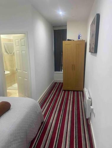 a bedroom with a bed and a dresser and a carpet at *Cosy 1 bedroom apt nxt to Roundhay and centre * in Roundhay