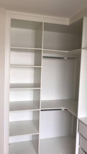 a white closet with empty shelves in a room at Duplex - 2 dormitórios (único c/ closet)¹⁷¹⁵ in Sao Paulo