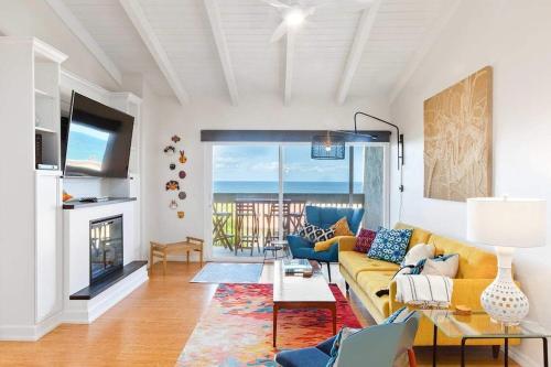a living room with a yellow couch and a fireplace at Solana Beach Sol condo in Solana Beach