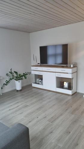 uma sala de estar com uma televisão de ecrã plano e um sofá em Annes Hus em Rødekro