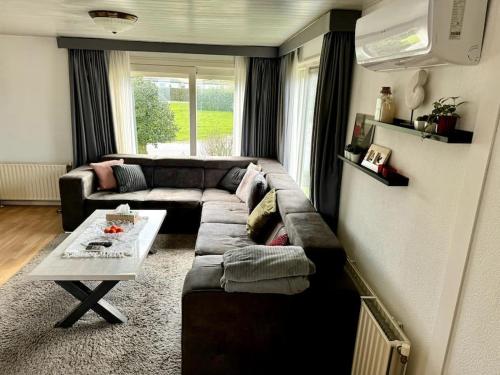 a living room with a couch and a table at Luxe chalet in prachtig natuurgebied in Lith