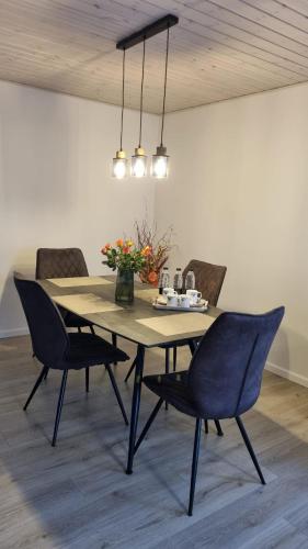 Annes Hus في Rødekro: طاولة طعام مع كراسي وطاولة مع زهور