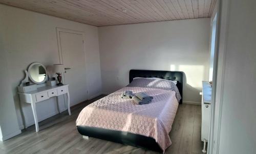 een kleine slaapkamer met een bed en een spiegel bij Annes Hus in Rødekro