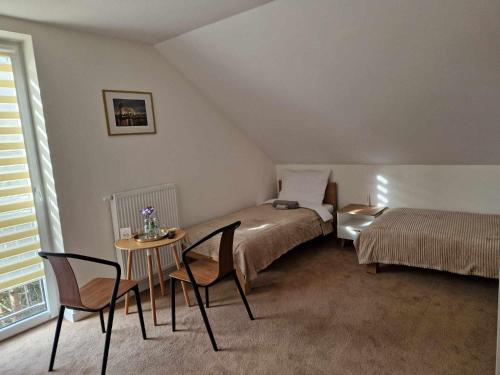 um quarto com 2 camas, uma mesa e cadeiras em Noclegi Nad rzeką Białą em StrÃ³Å¼e