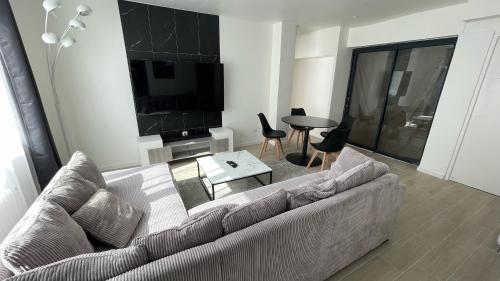a living room with a couch and a tv and a table at Appartement hyper centre - Coty in Le Havre