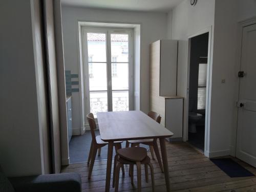 une cuisine avec une table et des chaises dans une pièce dans l'établissement studio hyper centre la rochelle, à La Rochelle