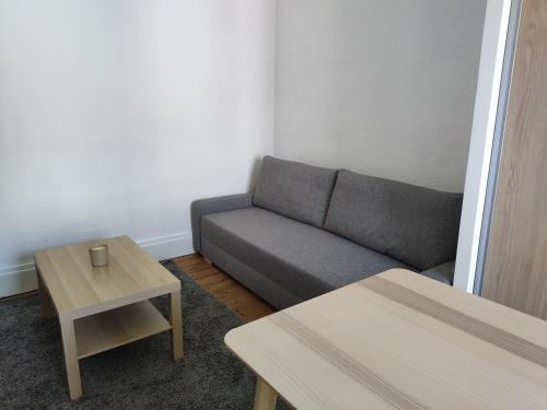 un salon avec un canapé et deux tables dans l'établissement studio hyper centre la rochelle, à La Rochelle