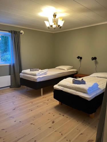 two beds in a room with wooden floors at Hus i Väse, utanför Karlstad in Väse