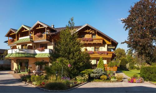 a large house with flowers in front of it at Garten - Hotel Sallerhof in Salzburg