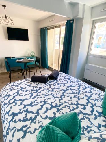 une chambre avec un lit et une table avec des chaises dans l'établissement Le Tranquillou, à Sète