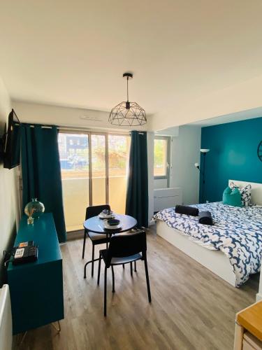 une chambre avec un lit, une table et des chaises dans l'établissement Le Tranquillou, à Sète