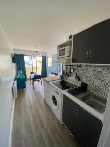 une cuisine avec un évier et une cuisinière four supérieur dans l'établissement Le Tranquillou, à Sète