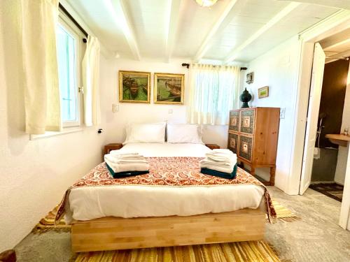 a bedroom with a bed with two towels on it at Olive Mill Cottage in Skopelos Town