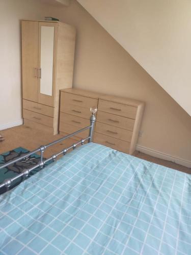 an attic bedroom with a bed and a dresser at Female Only Room in Bradford