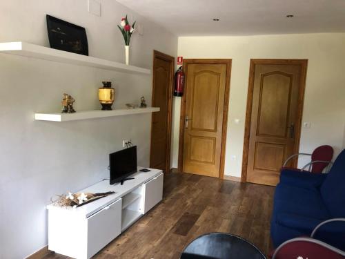 a living room with a tv on a white cabinet at Apartamentos Miravalles A in Villaviciosa