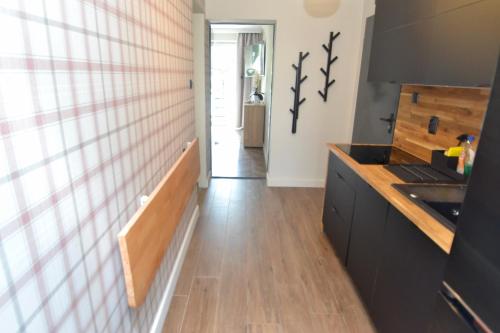 a kitchen with black cabinets and a wooden floor at Apartamenty Admirał  in Solina