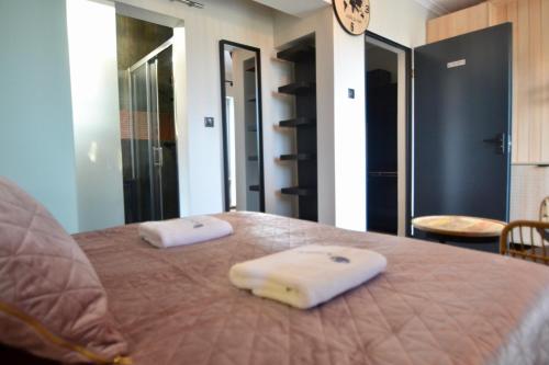 two towels are sitting on a bed in a room at Apartamenty Admirał  in Solina