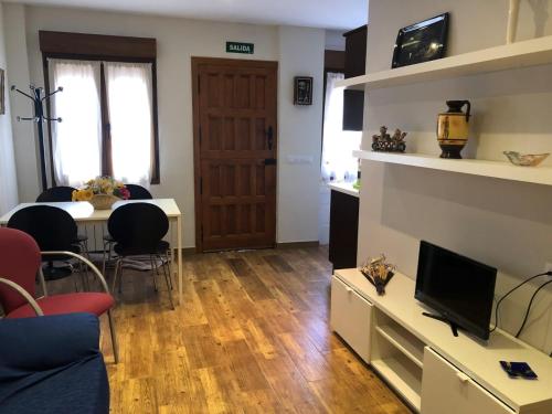 a living room with a table and a tv at Apartamentos Miravalles A in Villaviciosa