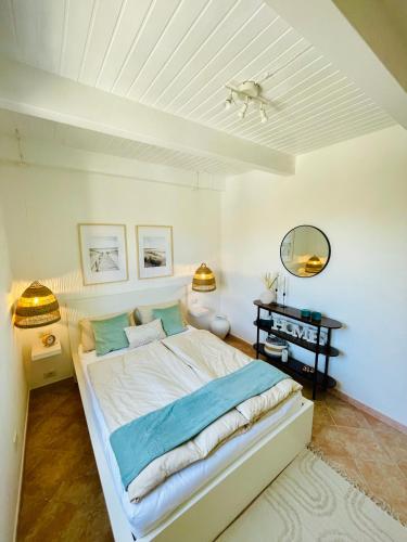 a white bedroom with a bed and a desk at Casa del Sole in Murta Maria