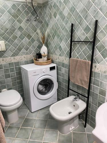 a bathroom with a washing machine and a toilet at Casa del Sole in Murta Maria