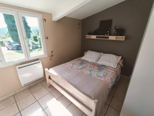 une petite chambre avec un lit et une fenêtre dans l'établissement gîte en provence, à Peypin