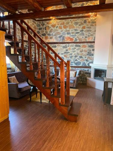 a wooden staircase in a room with a stone wall at Gioras Hotel in Palaios Agios Athanasios