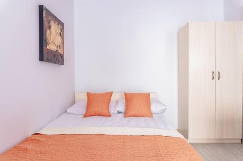 a bedroom with a bed with orange pillows on it at Willa Bliźniak 2 - Wyżywienie wliczone w cenę in Karwia