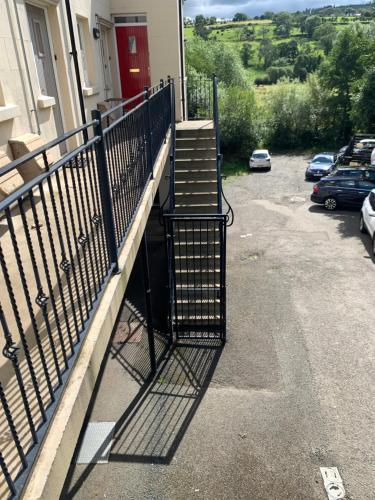 a balcony with a fence and stairs on a house at Seaside Apartment - 2 storey 2 bedrooms in Ballycastle