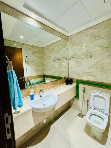 a bathroom with a sink and a toilet and a mirror at Luxurious Room with Dedicated Bathroom Near Rigga Metro with all Modern Facilities in Dubai