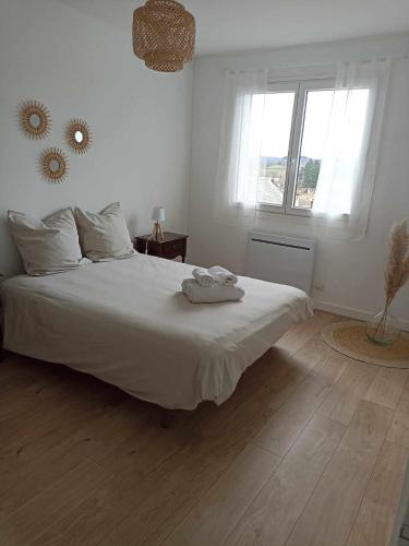 1 dormitorio con cama blanca y ventana en Appartement Auzances en Auzances