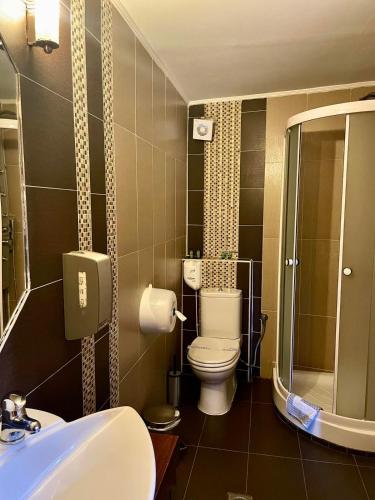 a bathroom with a toilet and a shower and a sink at Gioras Hotel in Palaios Agios Athanasios