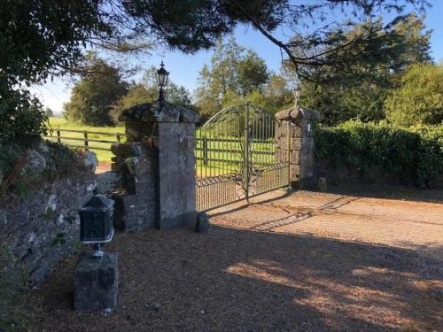 an entrance to a gate in front of a fence at Lackandarralodge large 5BR entire house sleeps14! in Dungarvan